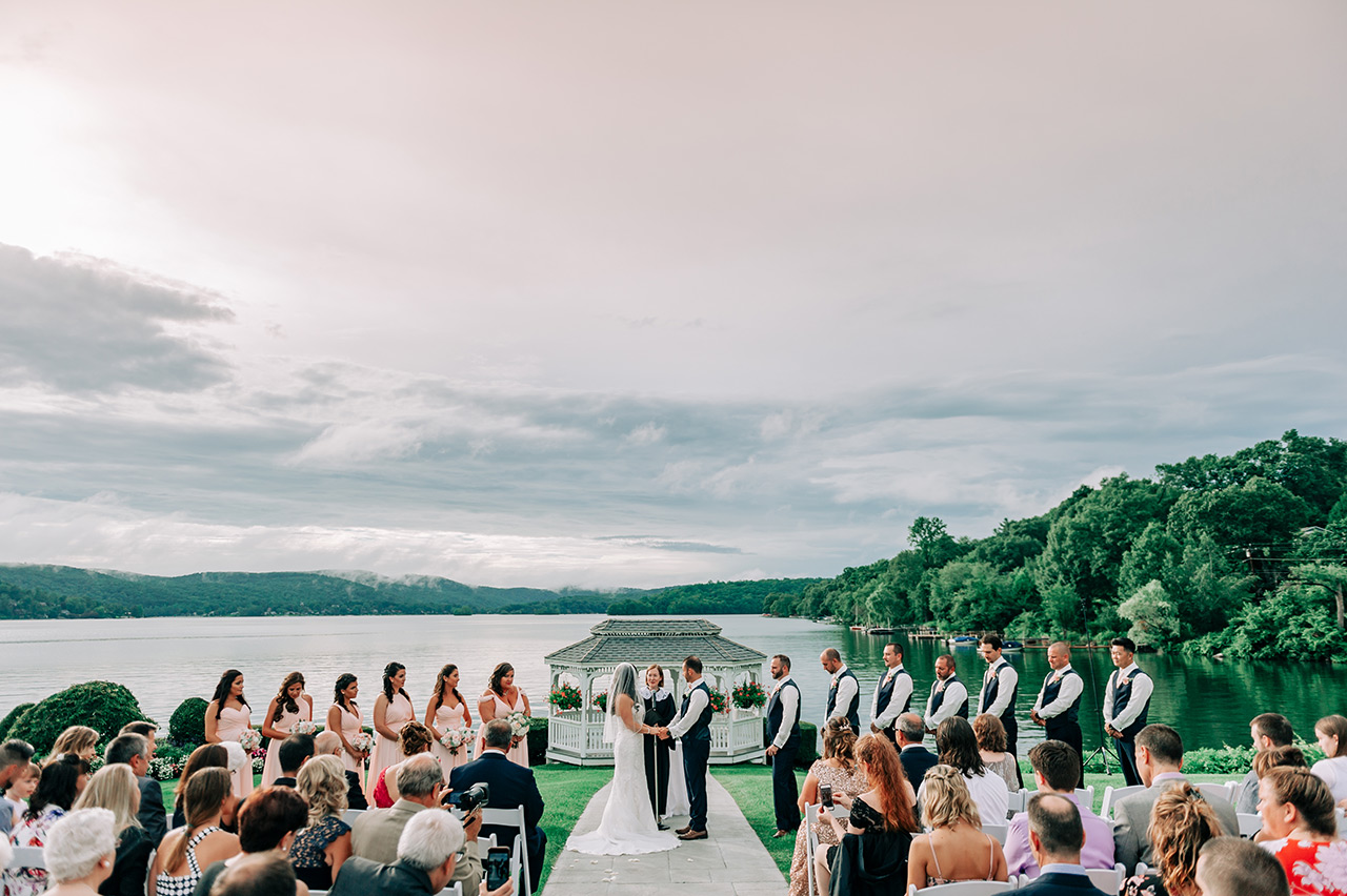 Lakeside wedding ceremony with guests gathered at Candlewood Inn waterfront venue.