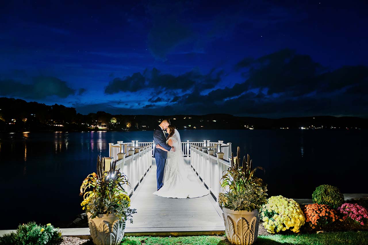 Bride and groom share a romantic lakeside moment on the dock at Candlewood Inn.