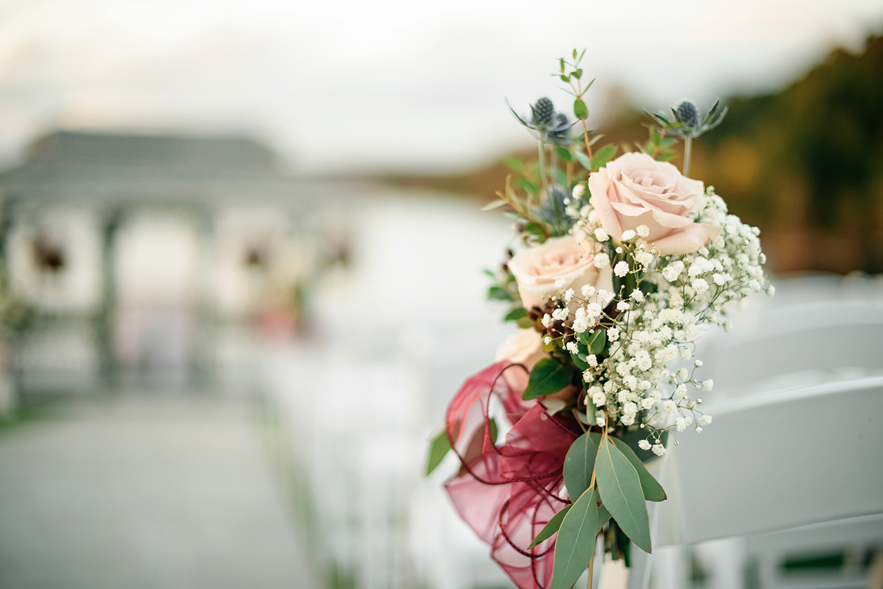 Floral aisle decoration with roses and greenery at a Candlewood Inn lakeside wedding.