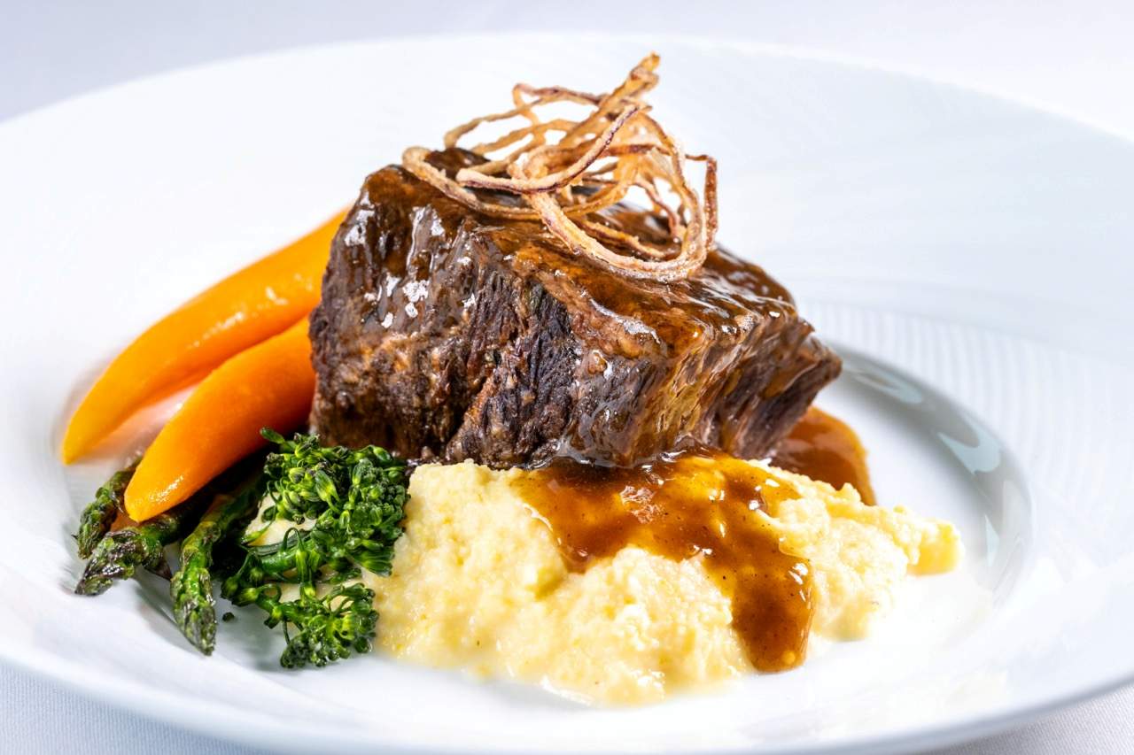 Short rib with creamy polenta, broccolini, and carrots at a Candlewood Inn reception.