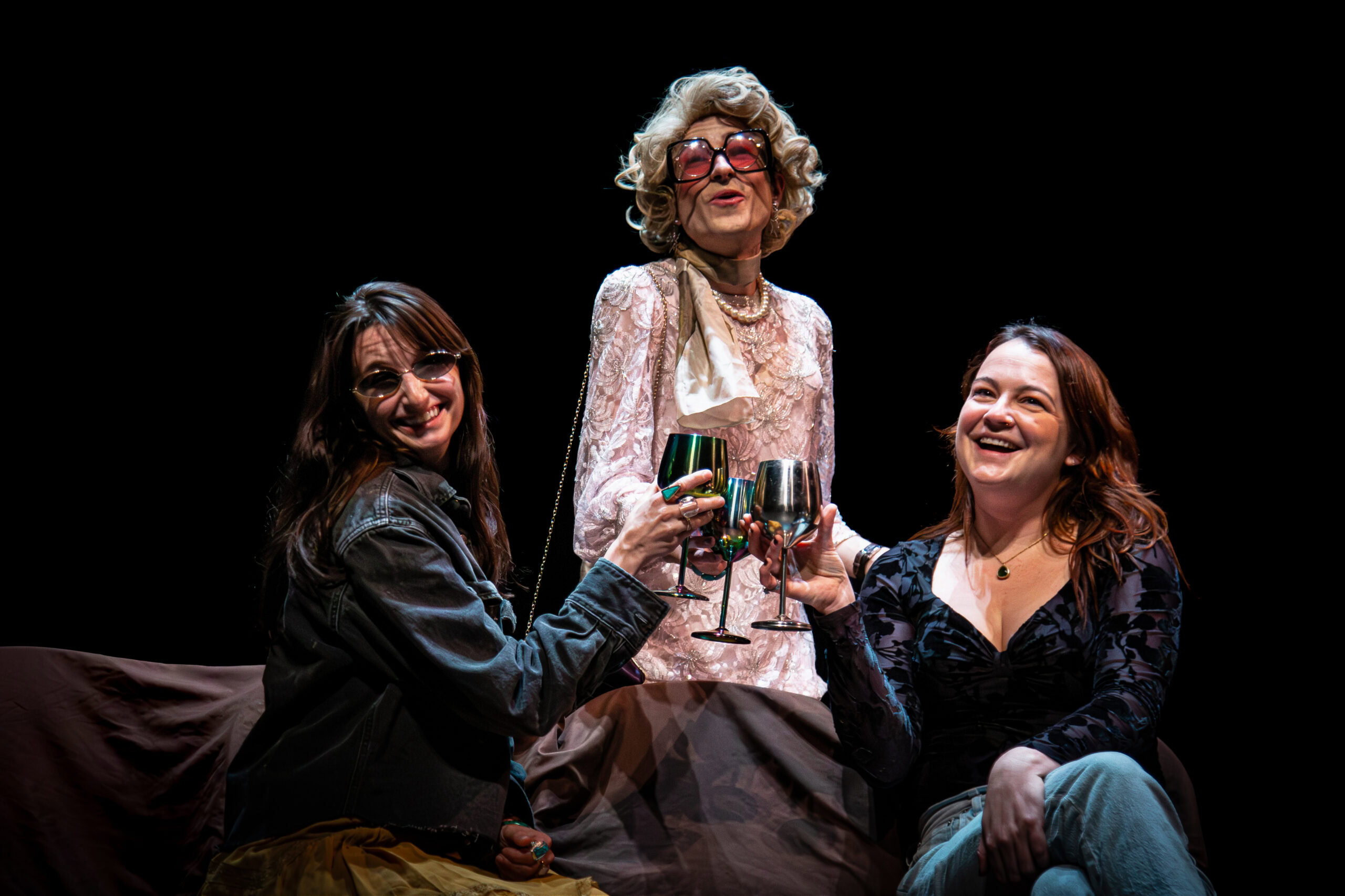 Three women on stage celebrating with wine glasses during The StageCrafts SpookyFest 2026, Hollywood's horror performing arts festival.