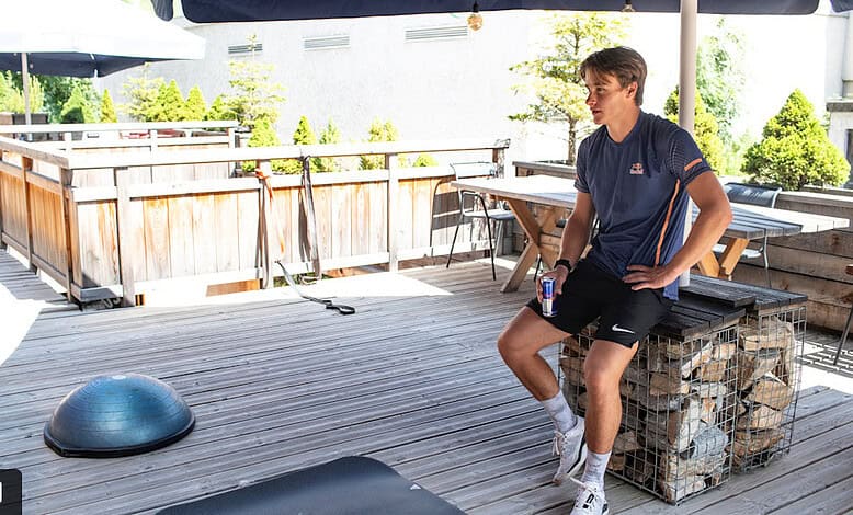 Refreshing outdoor space with winter sports equipment, featuring a young man relaxing after a workout, perfect for winter enthusiasts and fitness lovers seeking winter-themed relaxation and outdoor activities.