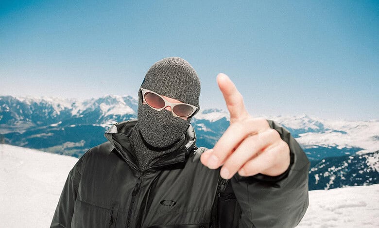 Skiers in winter gear on snowy mountain with clear blue sky, showcasing winter sports and outdoor adventure.
