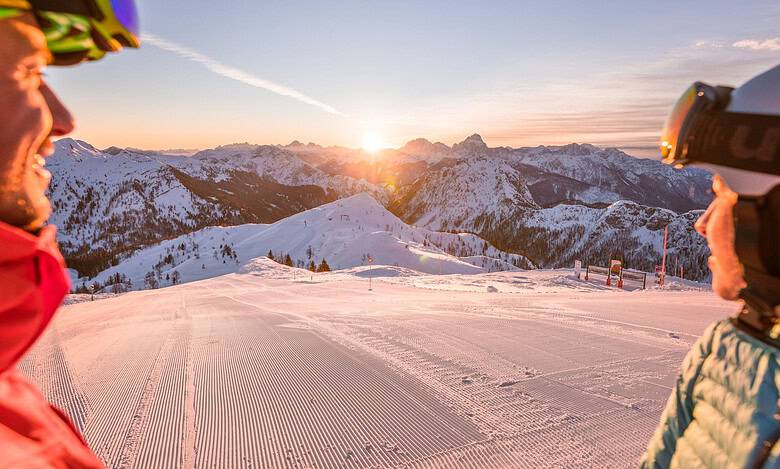 Scenic winter landscape in Carinthia, Austria with snow-covered mountains at sunrise, perfect for skiing and family holidays.