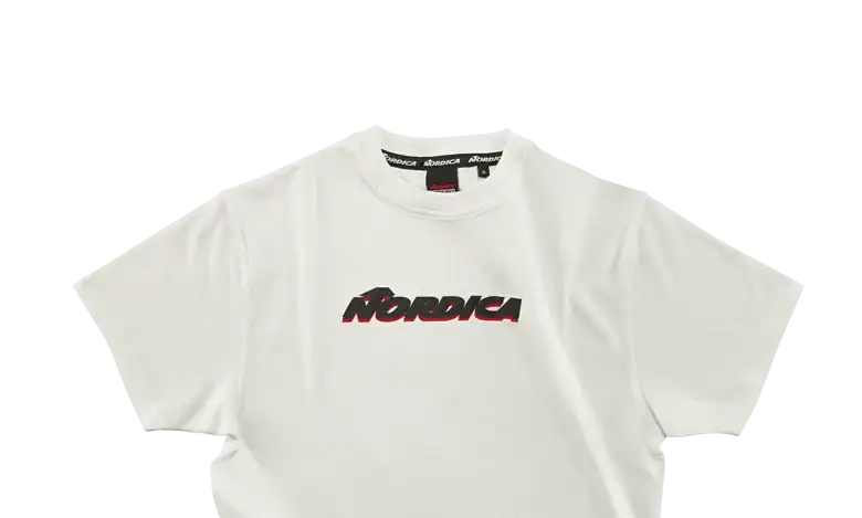 White Nordica branded T-shirt designed for winter sports enthusiasts, featuring bold black and red logo on the front, ideal for winter activities and casual wear.