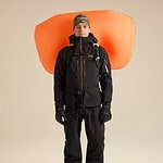 Climber with Arc'teryx Micon LiTRIC 16 avalanche airbag backpack, dressed in winter mountaineering gear, ready for snow safety in winter conditions.
