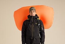 Climber with Arc'teryx Micon LiTRIC 16 avalanche airbag backpack, dressed in winter mountaineering gear, ready for snow safety in winter conditions.