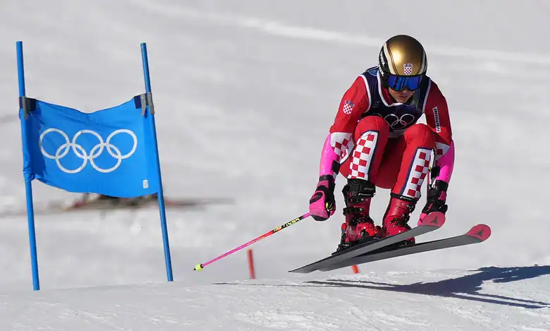 Female alpine skier in red and pink racing suit navigating a slalom course during a World Cup event in Sölden, Austria.