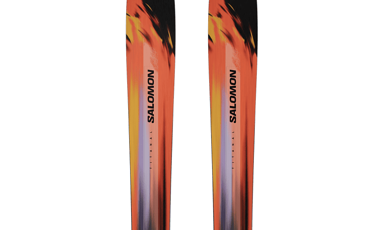 Pair of Salomon skis with vibrant orange, black, and yellow design, ideal for winter skiing adventures.