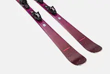 Pair of pink skis with black bindings designed for winter skiing activities.