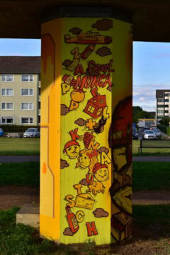 Bunte Wandmalerei mit Alphabetschrift, Figuren und Stadtmotiven, kreative Kunst im öffentlichen Raum.