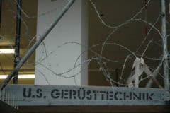 Verteidigung von US-Gerüstetechnik mit Stacheldrahtzaun an einem Baugerüst.