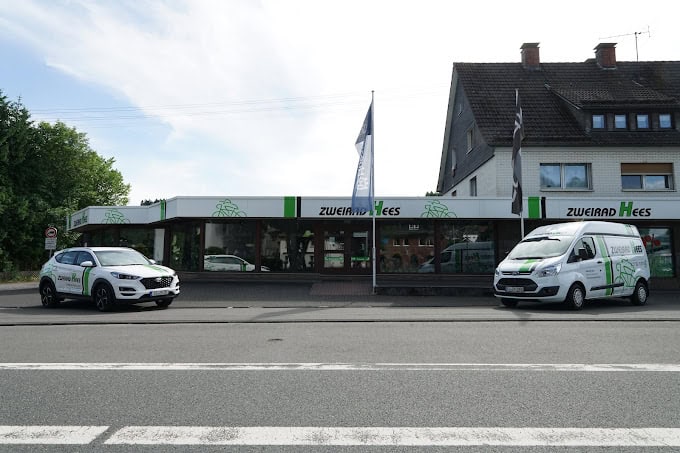 Außenansicht des Zweirad Hees Geschäfts mit Fahrzeugen vor dem Laden.