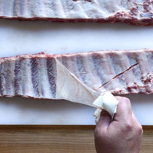 An image of two racks of ribs showing how the membrane on the bone side is removed.