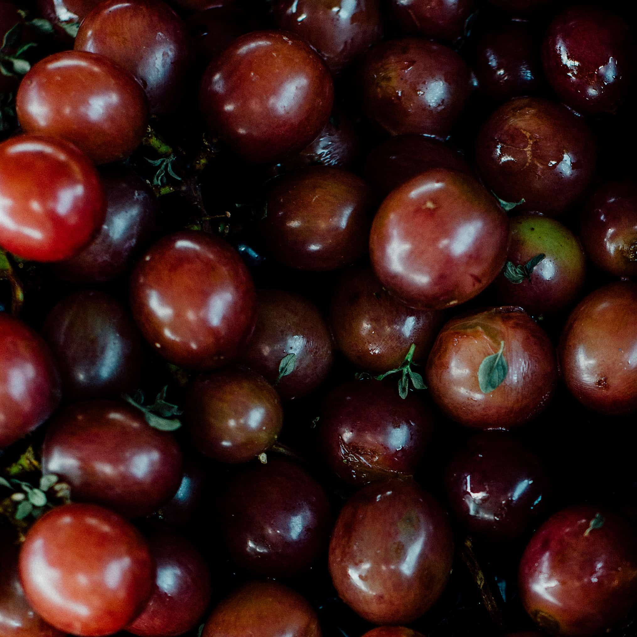 A close up of roasted grapes in a skillet.