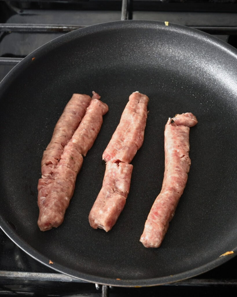 Break up the sausage in a pan with a wooden spoon.