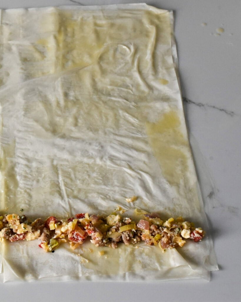 Spread out a row of filling along the edge and roll into a tube