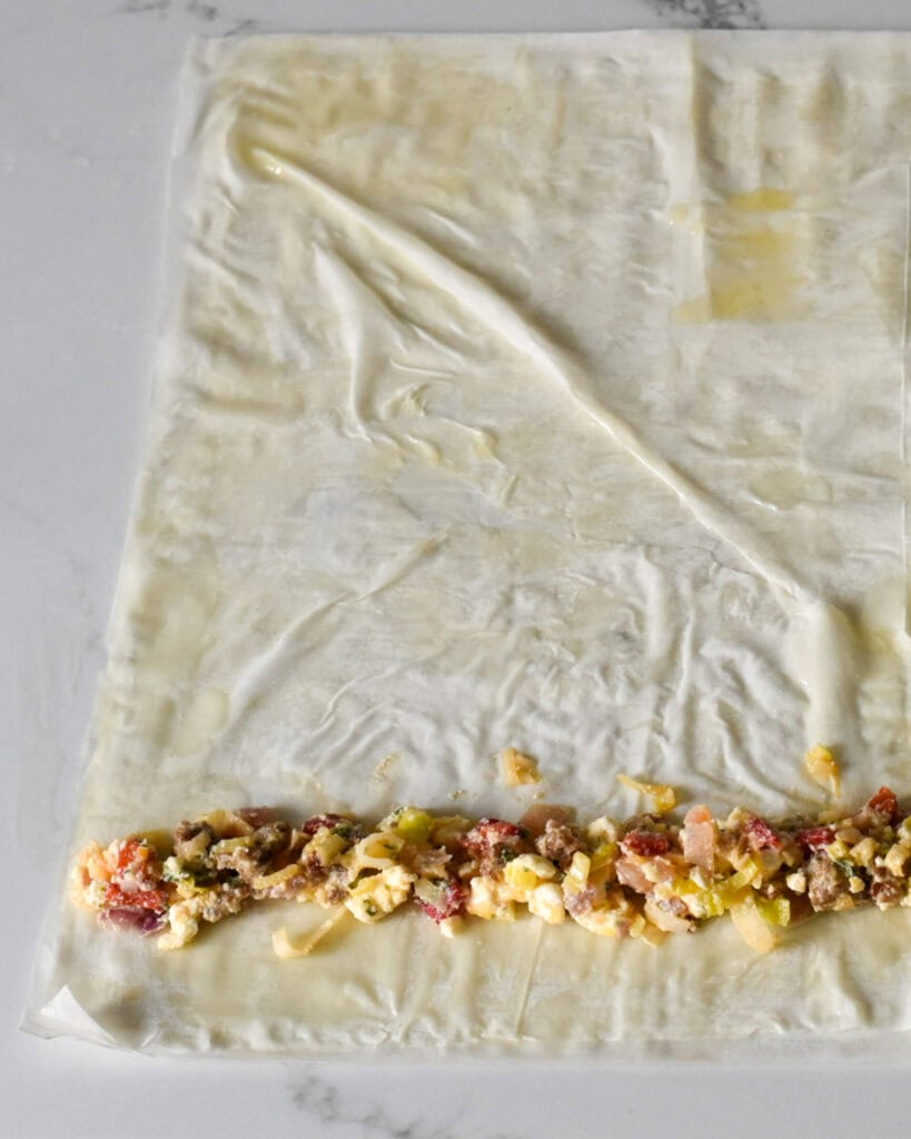 Spread out a row of filling along the edge and roll into a tube