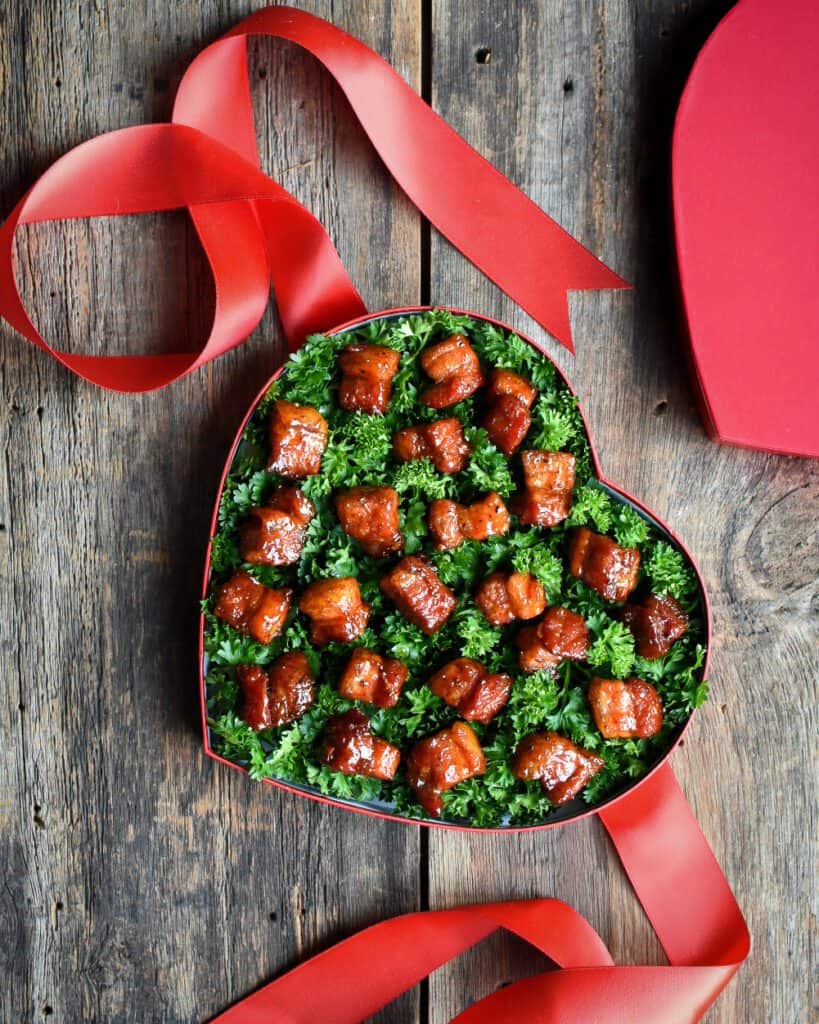 A red Valentine heart box filled with Pork burnt ends.
