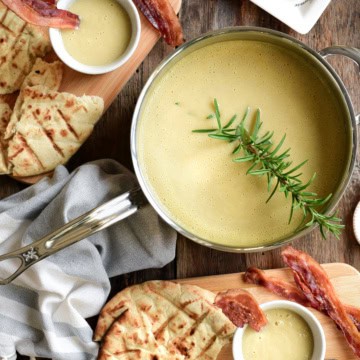 Leed and potato soup served in cups and garnished with a piece of bacon.