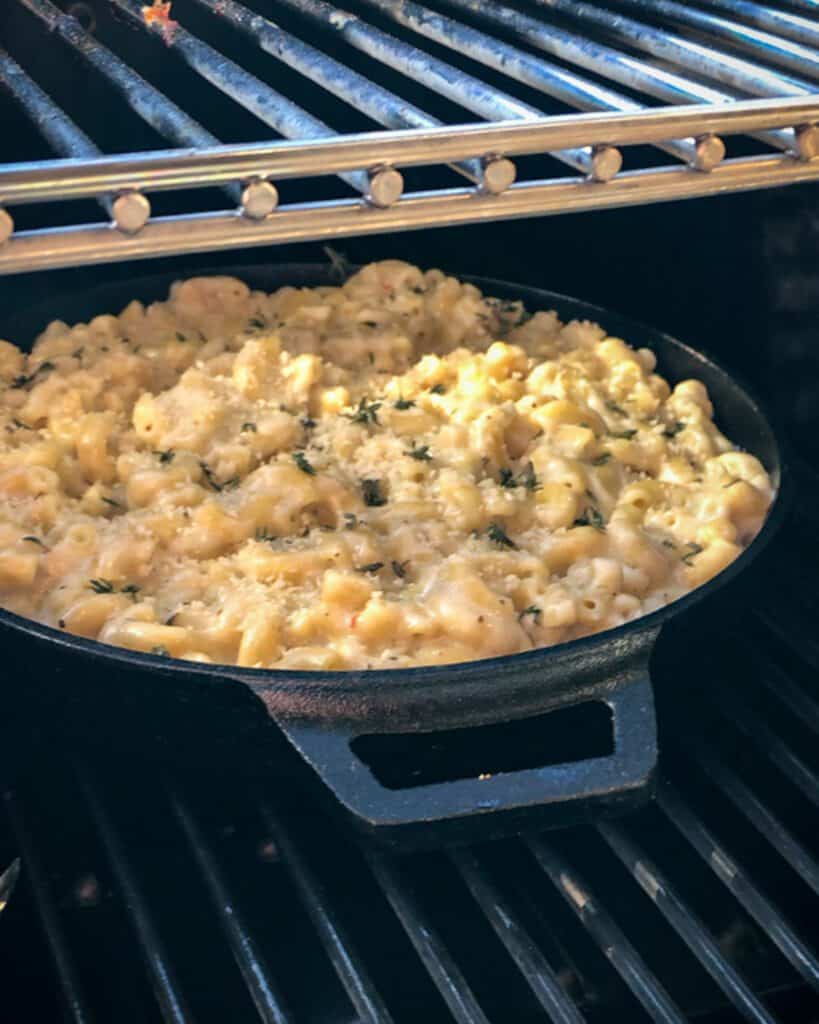 A round skillet of mac and cheese on a grill.