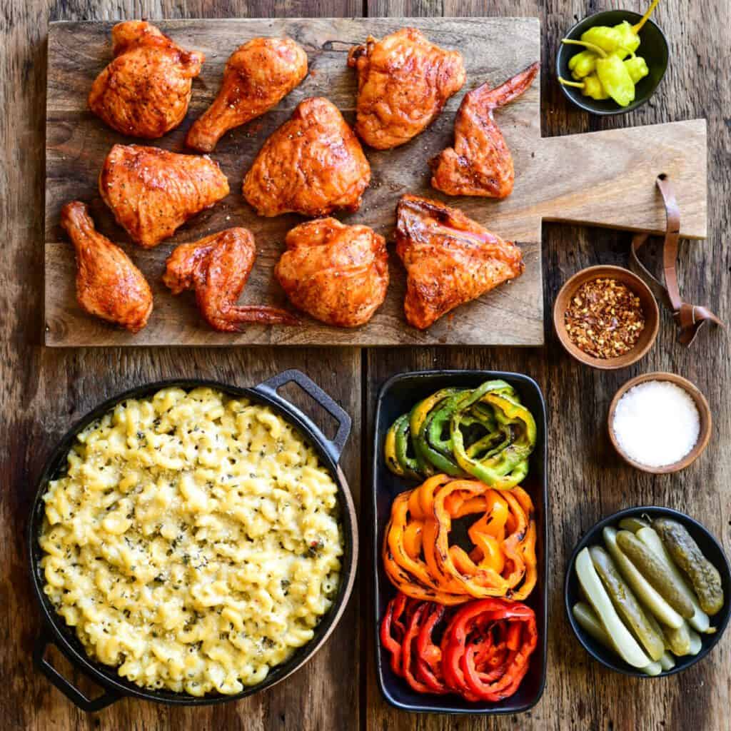 A skillet of mac and cheese with grilled chicken and peppers.