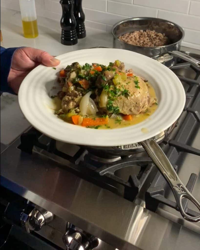This is any image of a plate of white wine chicken and chorizo stew on rice.