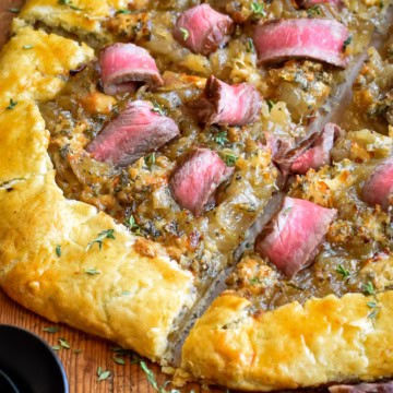 A close up of a steak and onion galette.