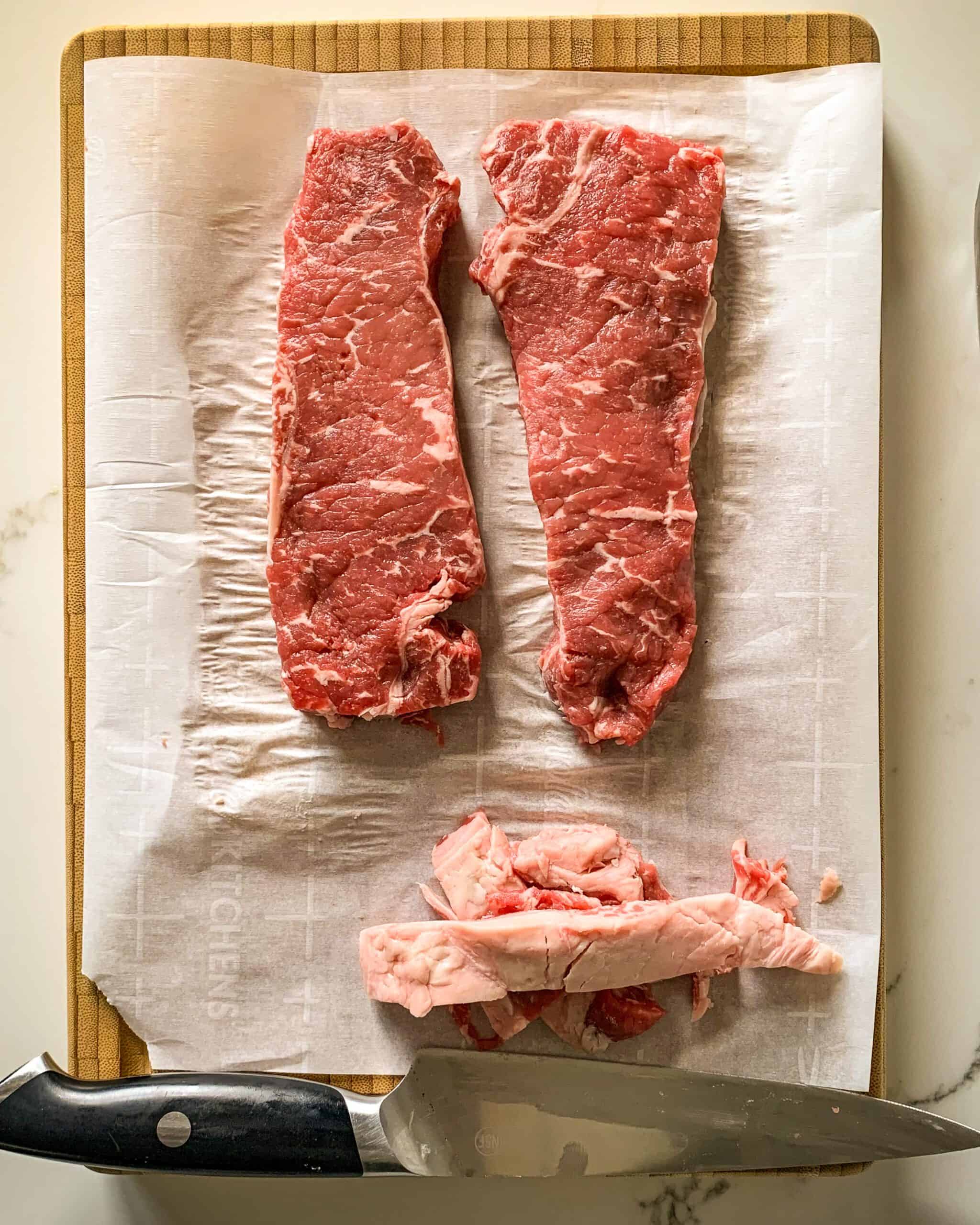 Two striploin steaks with fat removed.