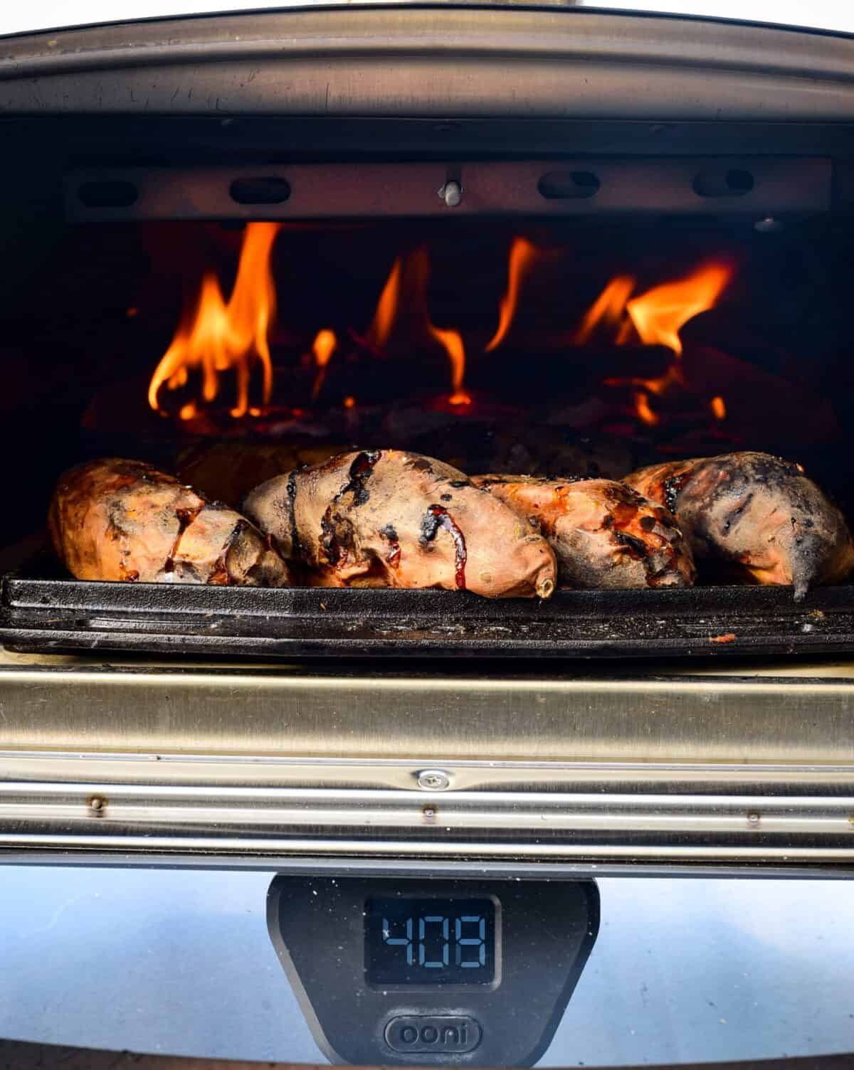 Baking sweet potatoes in a flaming wood oven.
