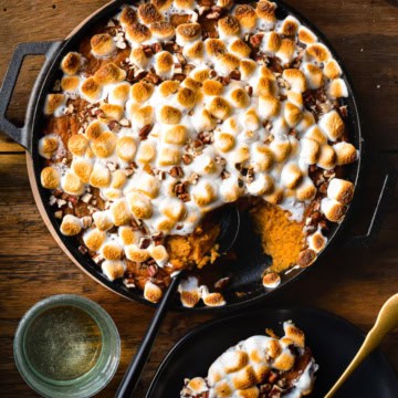 Wood-fired Sweet Potato Casserole in a cast iron skillet with a scoop taken out