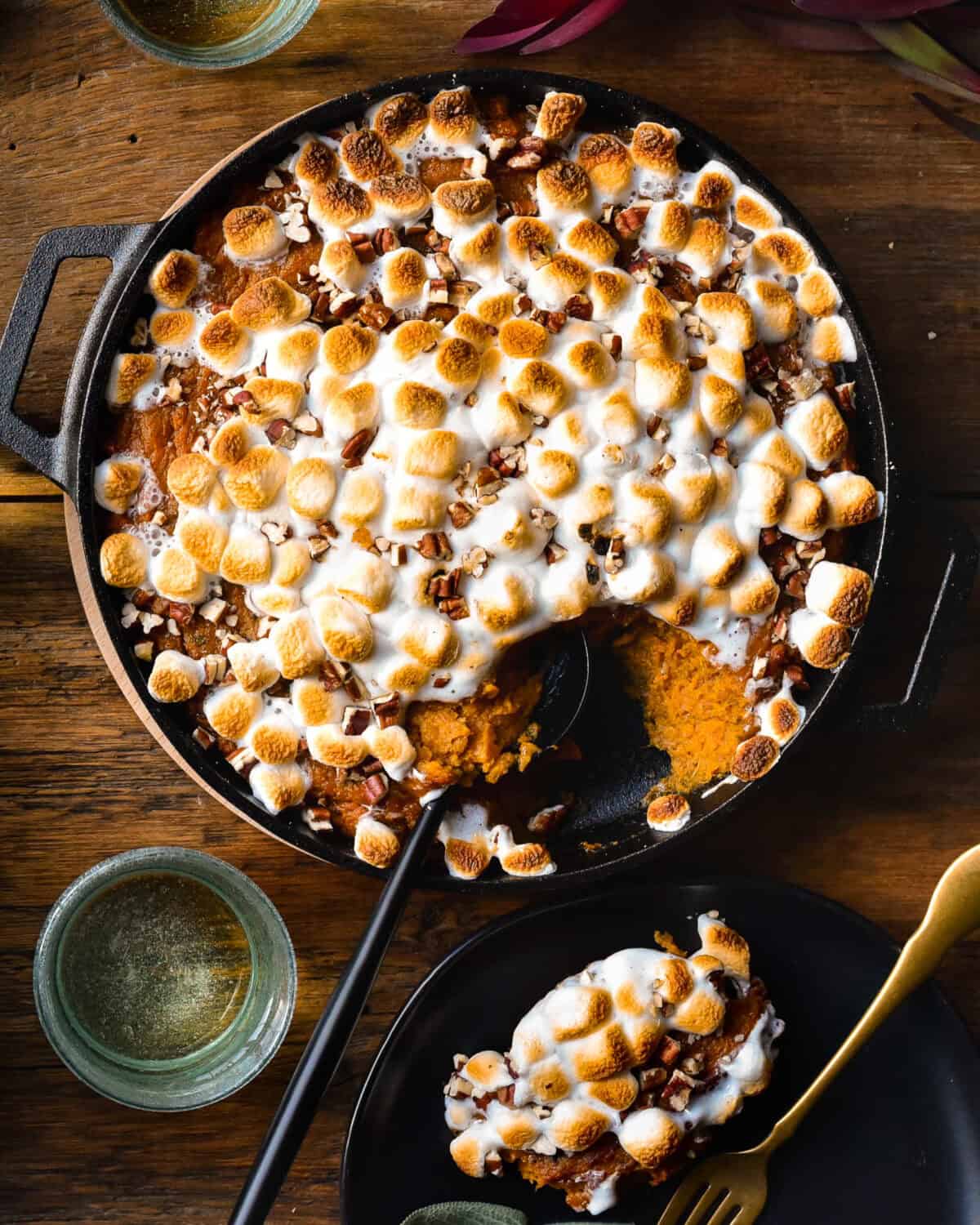 Wood-fired Sweet Potato Casserole in a cast iron skillet with a scoop taken out