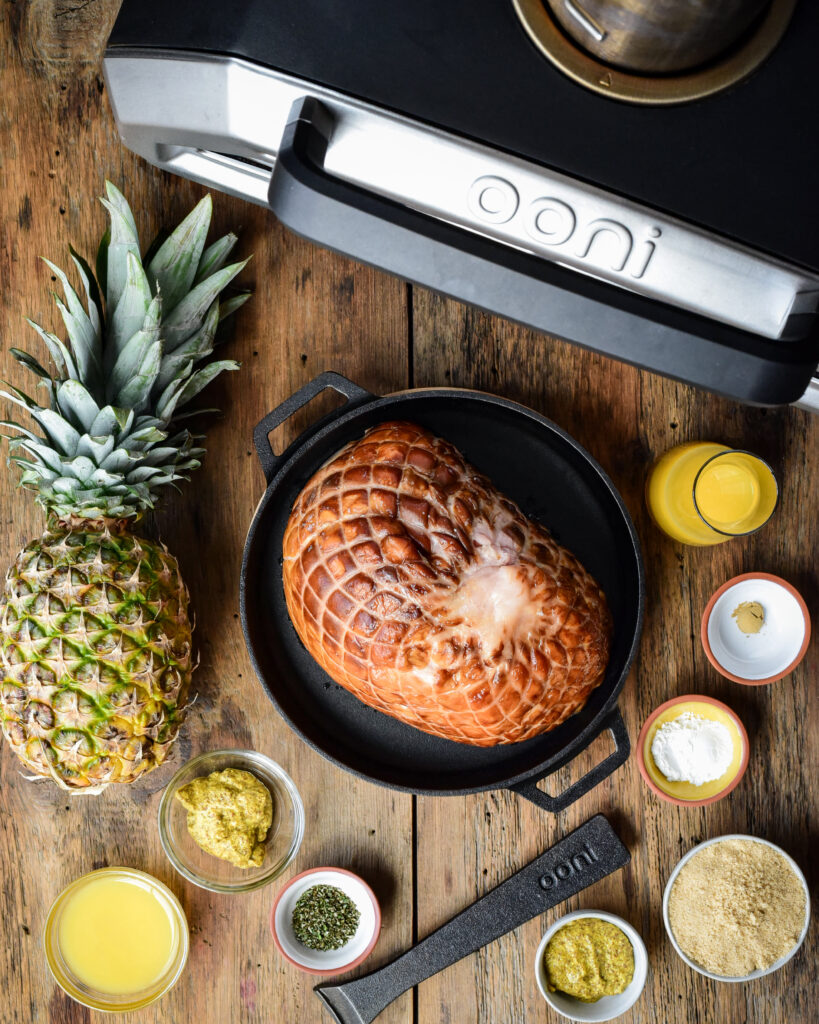 A pineapple, a ham, plus other ingredients to make a baked ham.