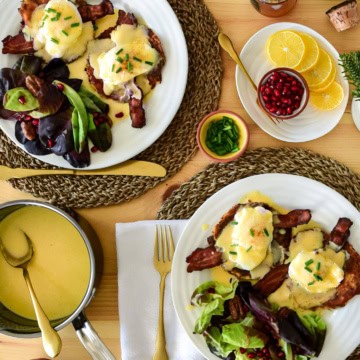 A top down image of two place settings of Eggs Benedict on Potato Pancakes