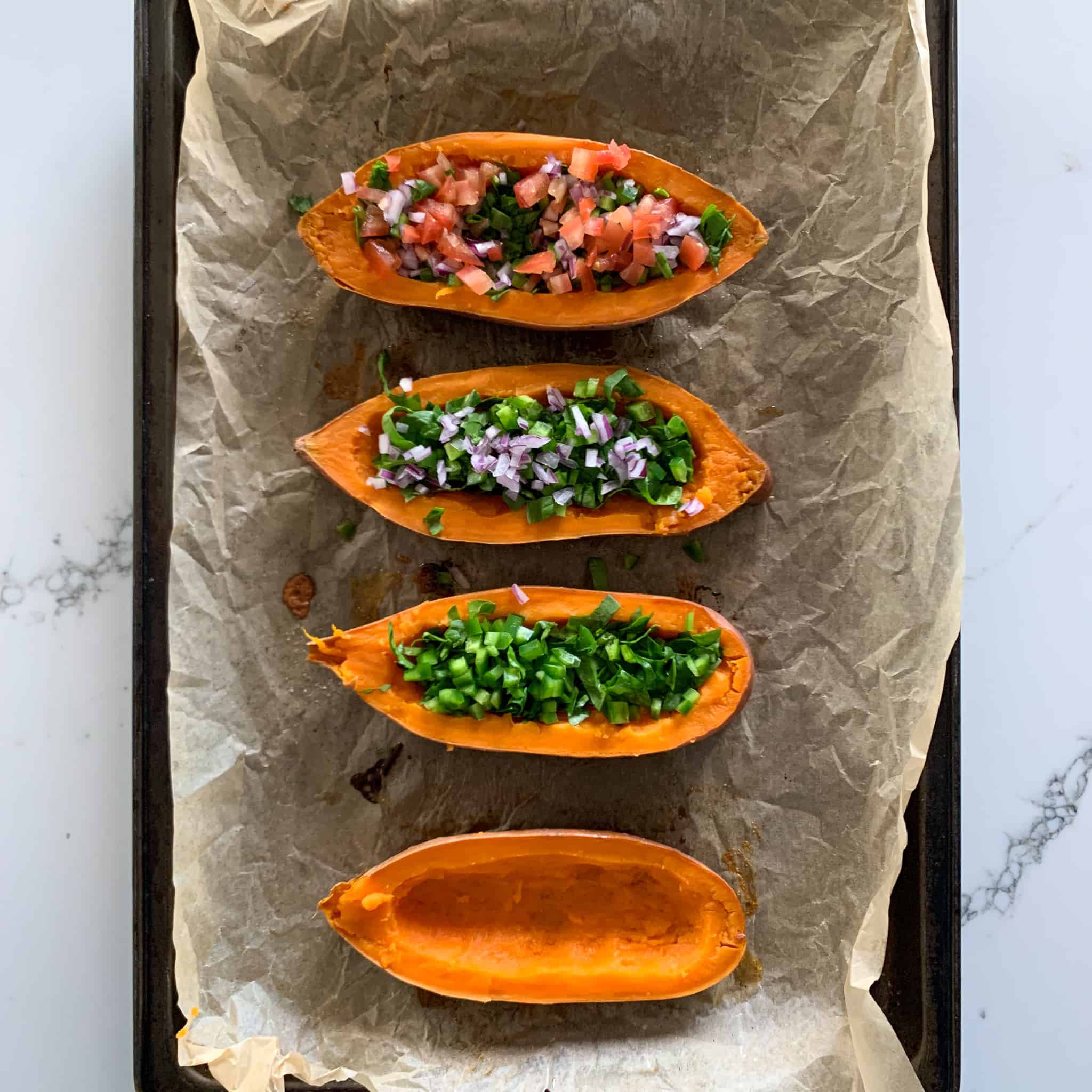 This image shows four half sweet potatoes getting filled at each stage.