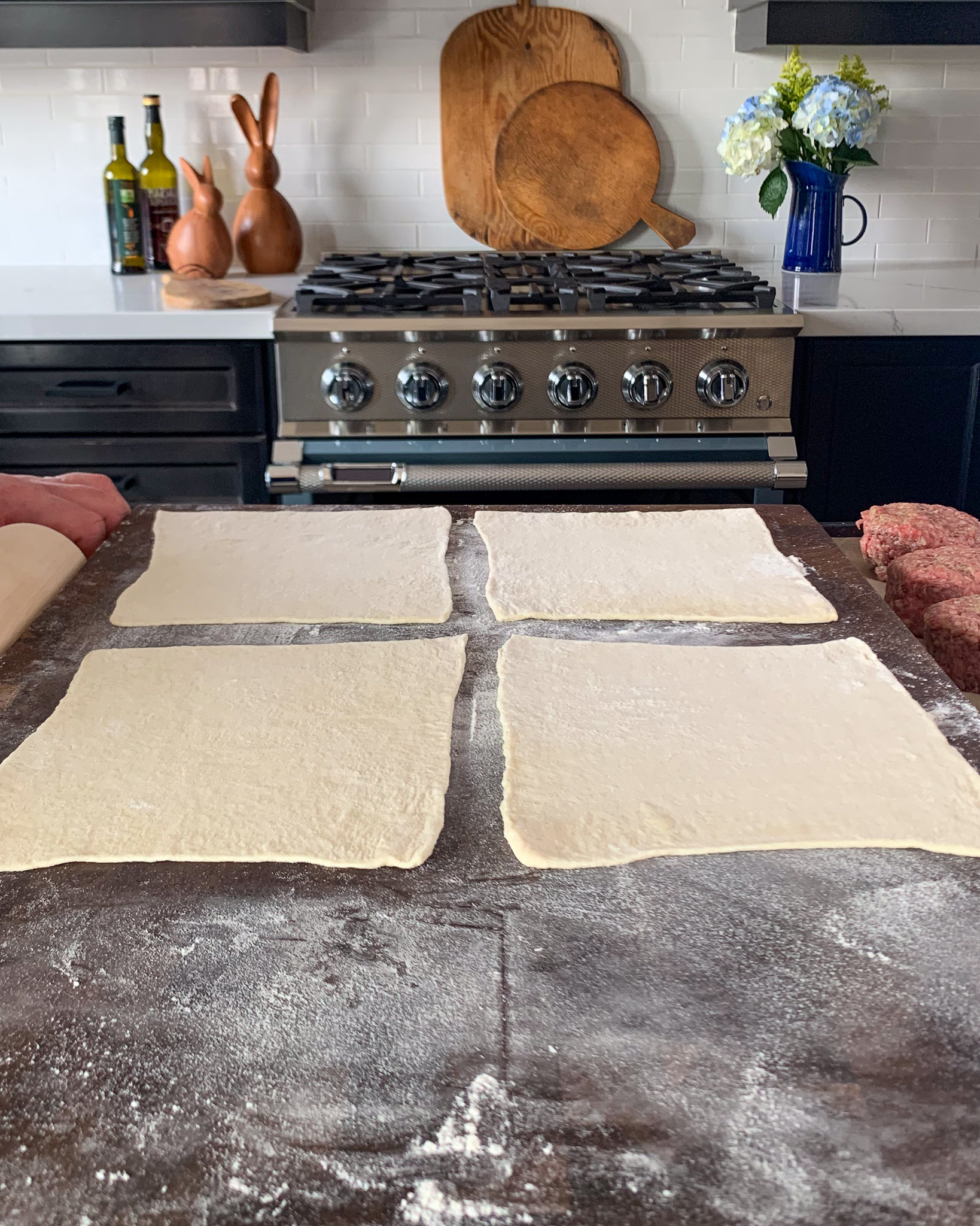 Roll out one sheet of the puff pastry on a lightly floured surface to a 12-inch square, then cut into 4 (6-inch) squares