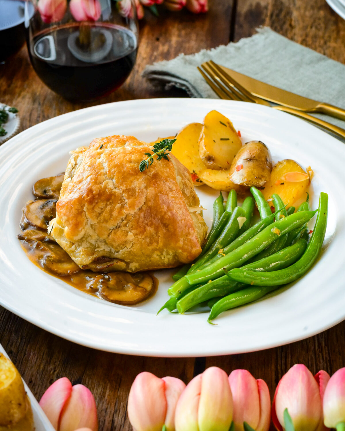 A plated portion with one Wellington in Marsala sauce with beans and potatoes.