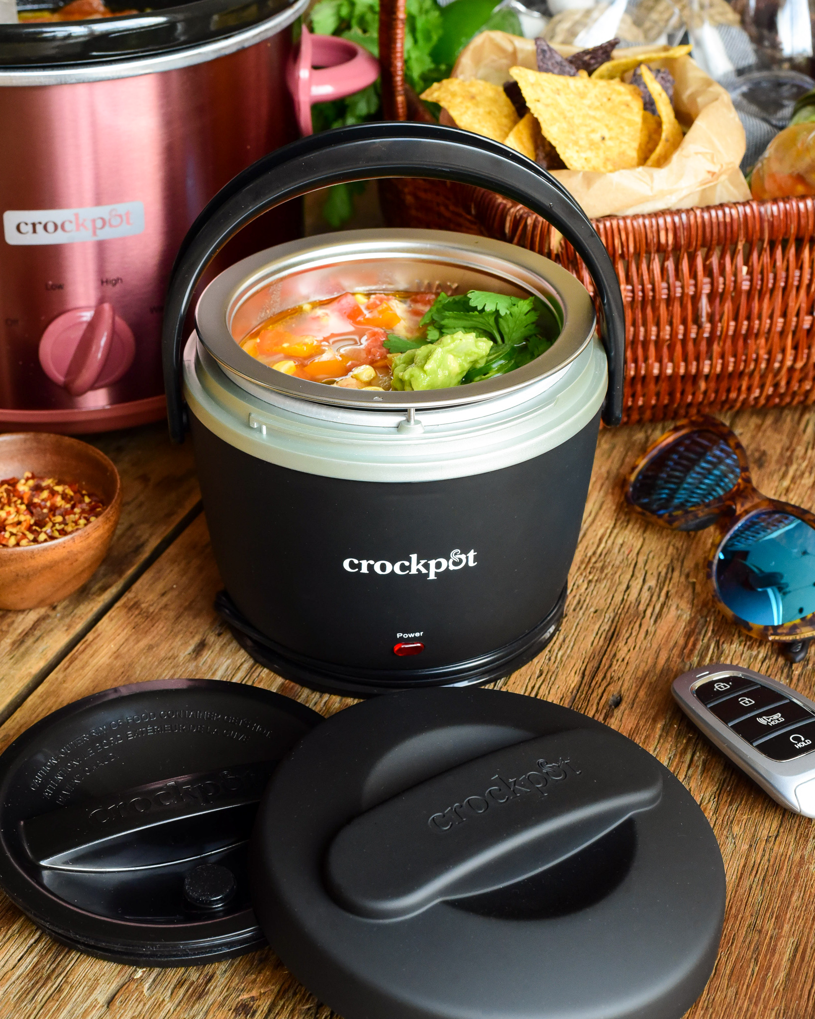 A mini black crockpot lunch crock filled with chilli ready to get the lids put on to take on a road trip.