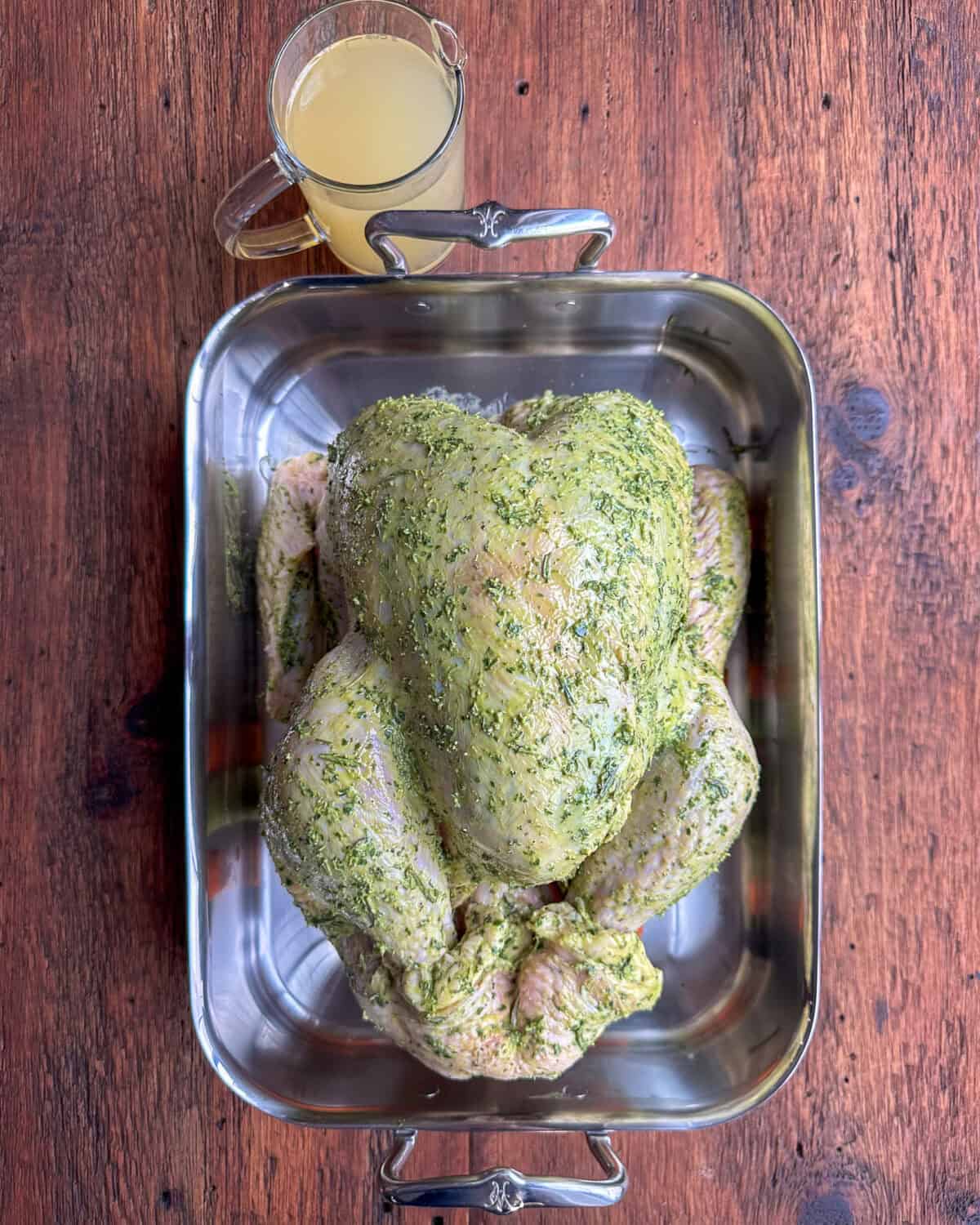 A prepped turkey smothered in an herb butter mixture.