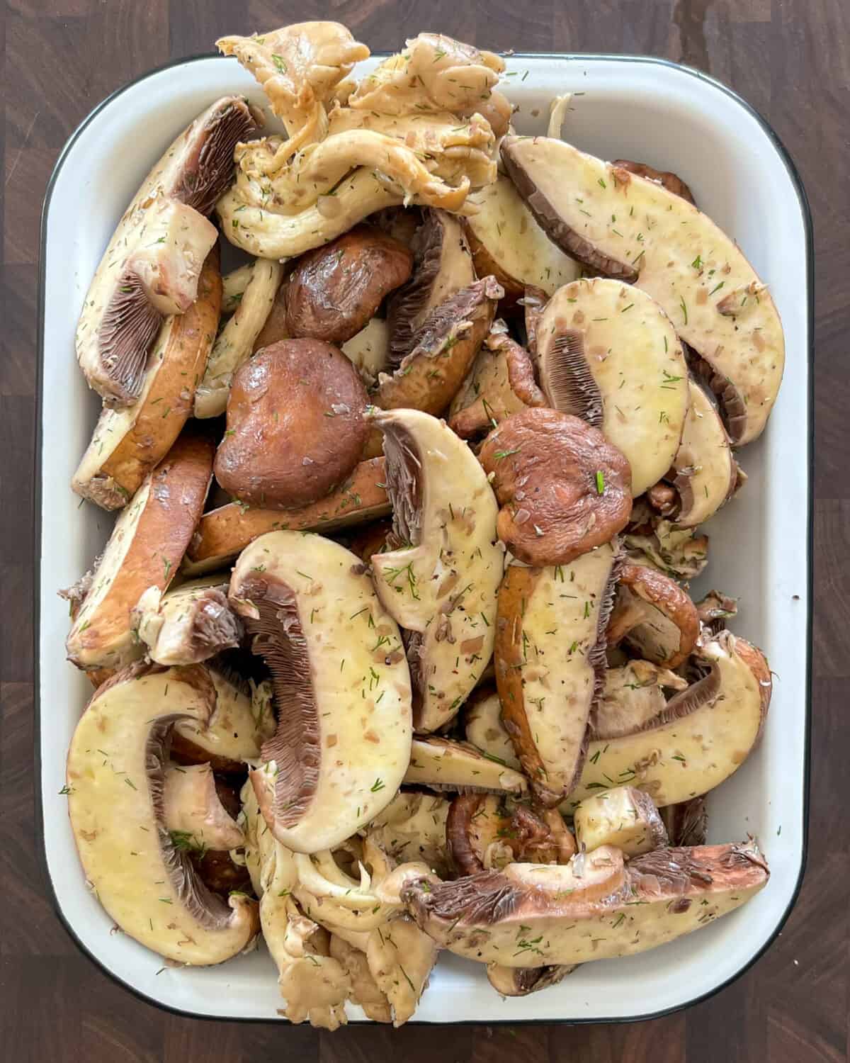 A rectangular dish of sliced and marinated mushrooms.
