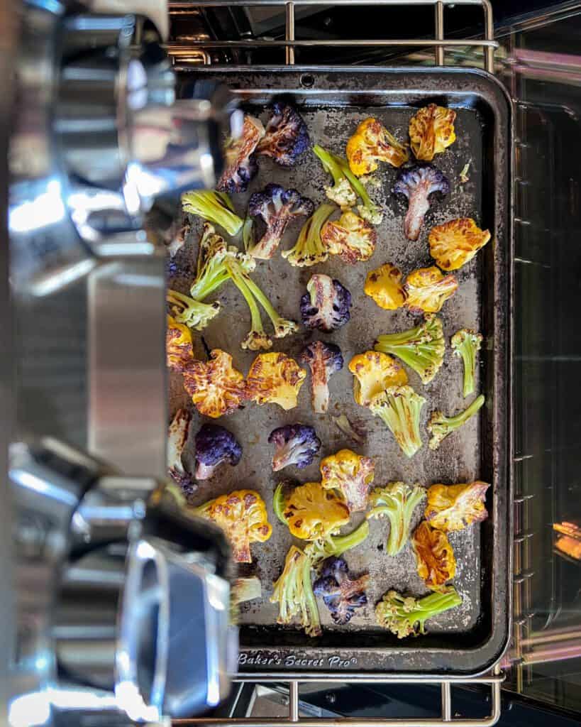 A top down image of tri-coloured roasted cauliflower coming out of the oven.