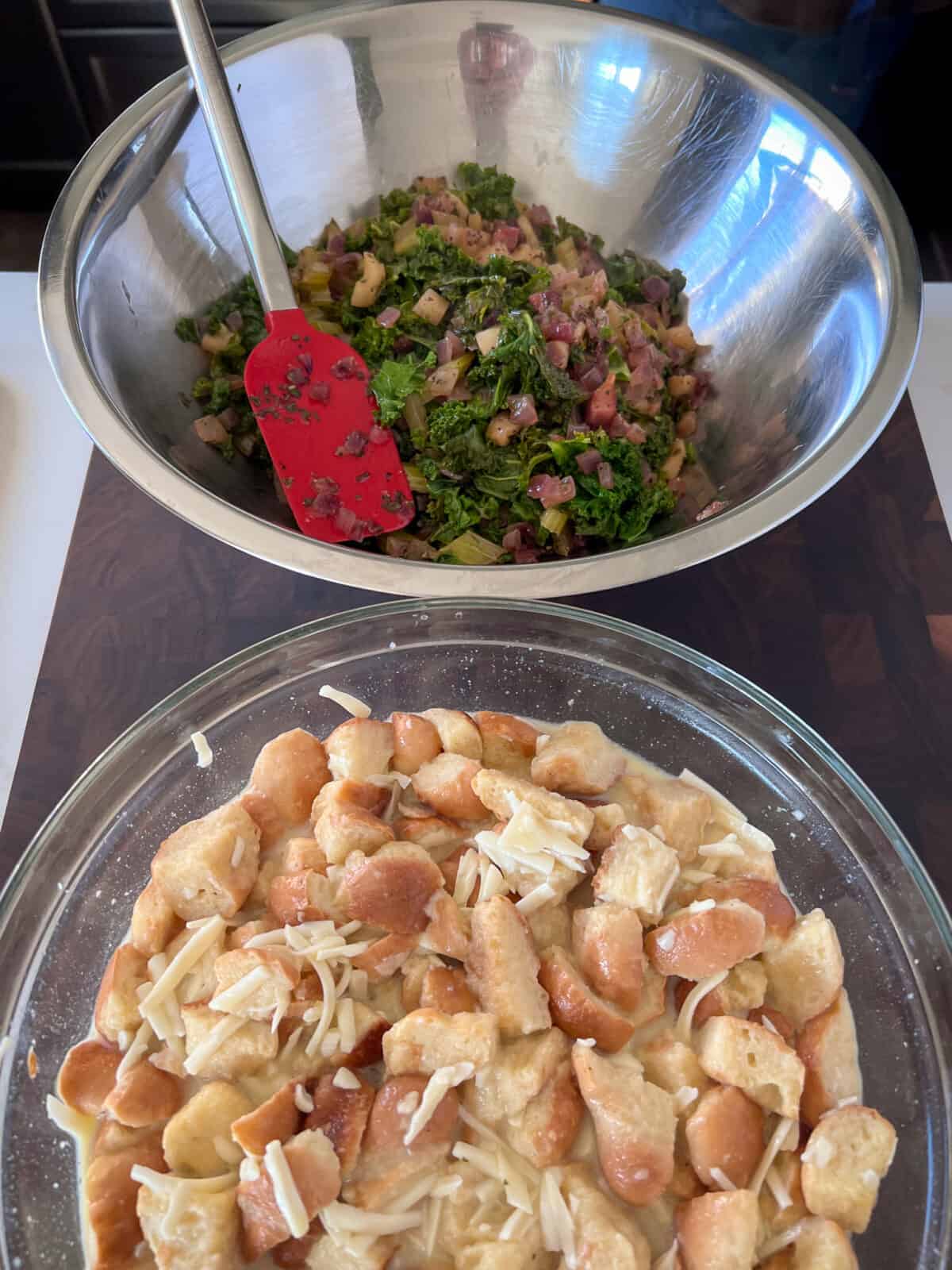 A bowl with the egg and bread mixture and a bowl of the vegetable mixture for the bread pudding.