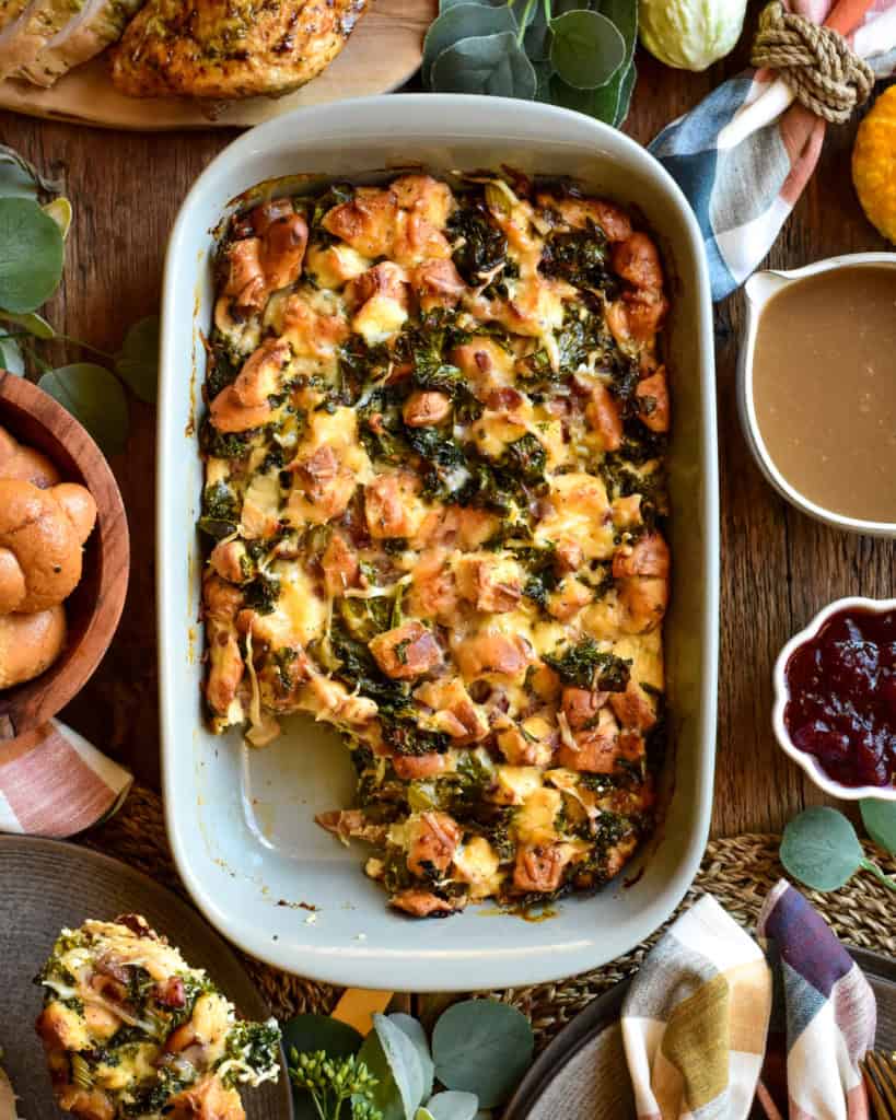 A retangular baking dish with a savoury bread pudding served with gravy and cranberries.