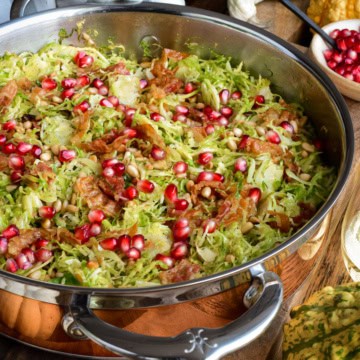 A copper pan with Shredded Brussels Sprouts with Pine Nuts, Pancetta and pomegranate arils.