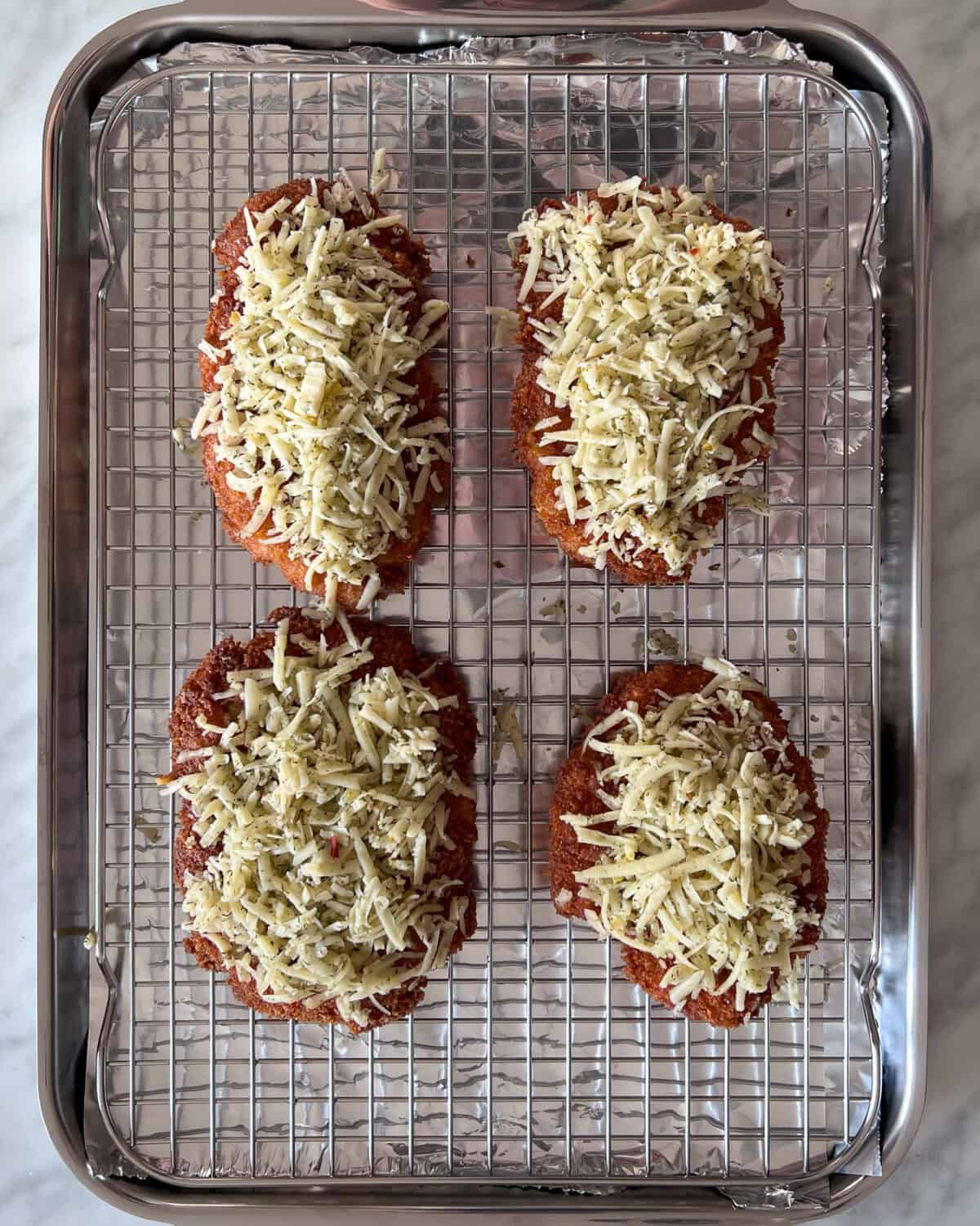 Add shredded cheese on the fried chicken.