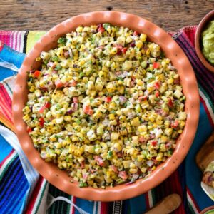 A terracotta bowl filled with a grilled corn salad.