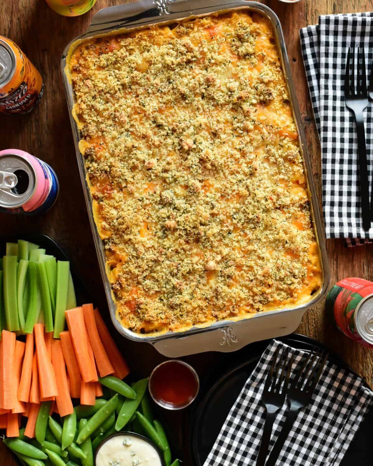 Buffalo Cauliflower Mac and Cheese just out of the oven and served with veggies, blue cheese dip and more buffalo sauce and cold beverage.