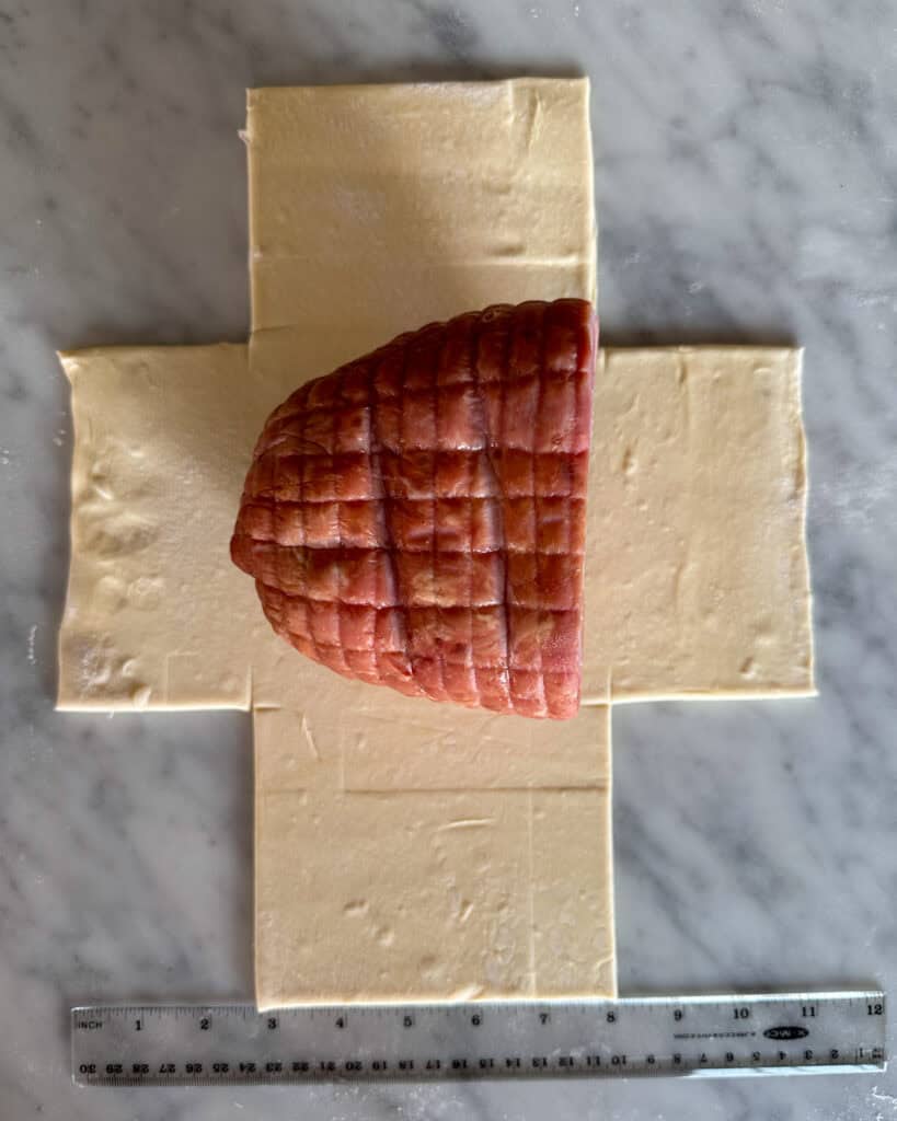 Roll out and cut the pastry into a "t", and place the ham in the center.