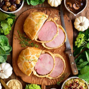 Two sliced ham wellingtons served with Marsala Mushroom Sauce, Shredded Brussels Sprouts with Pine Nuts and Pancetta, and smashed potatoes with thyme.