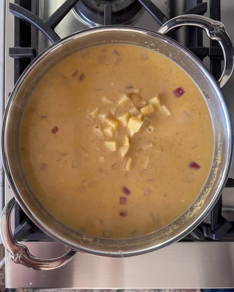 Adding potatoes into the yellow curry.